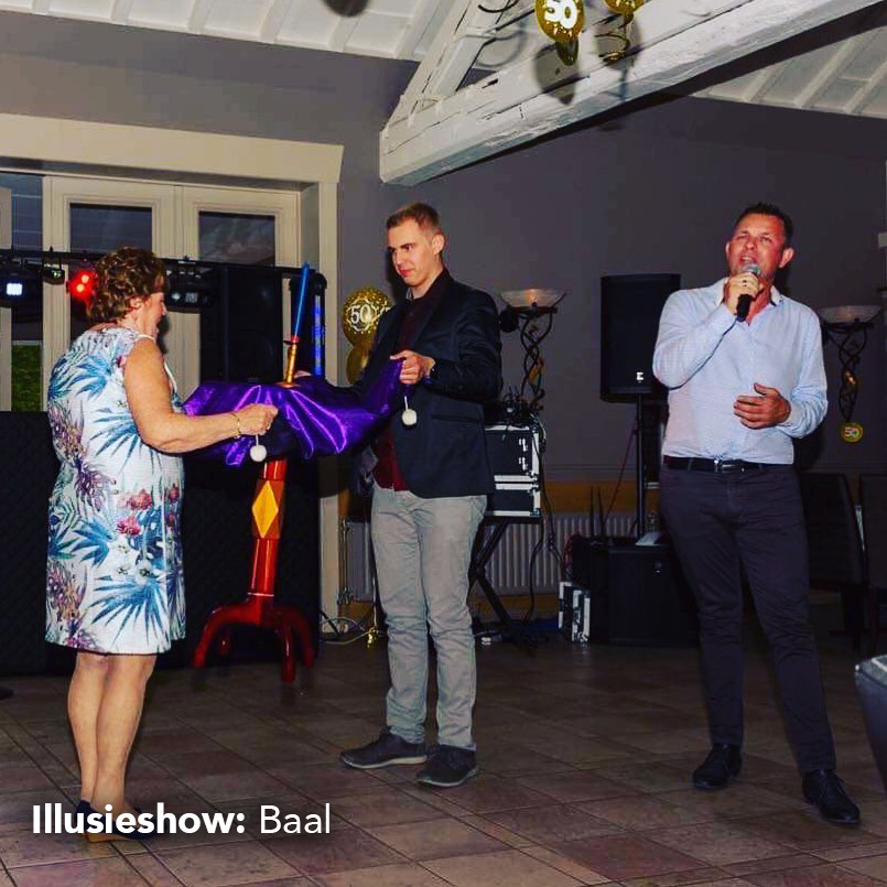 Goochelaar laat tafel zweven met zanger op de voorgrond